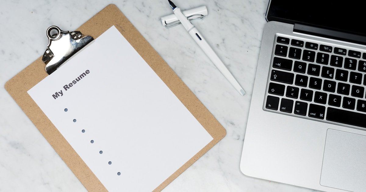 Professional writing an ex-consultant resume on a laptop to target PE and tech roles